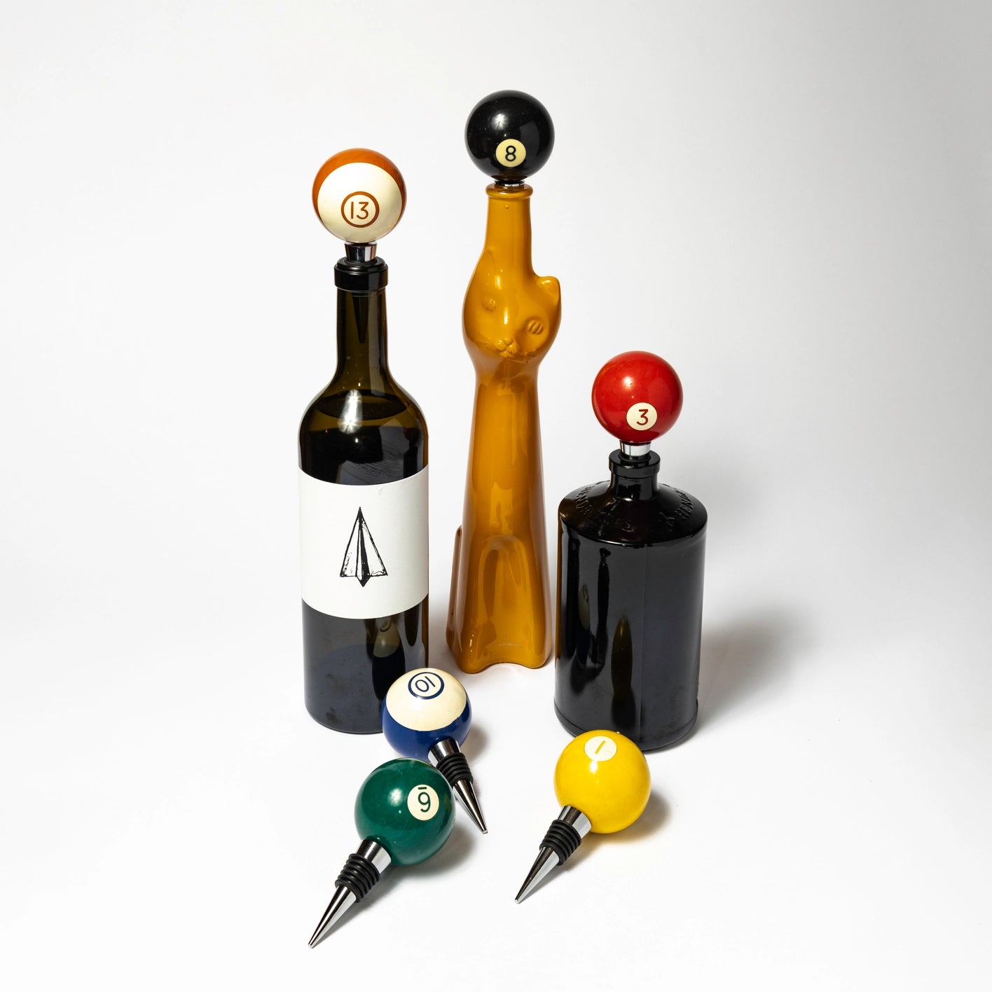 Set of bottle stoppers with billiard ball designs on a white background