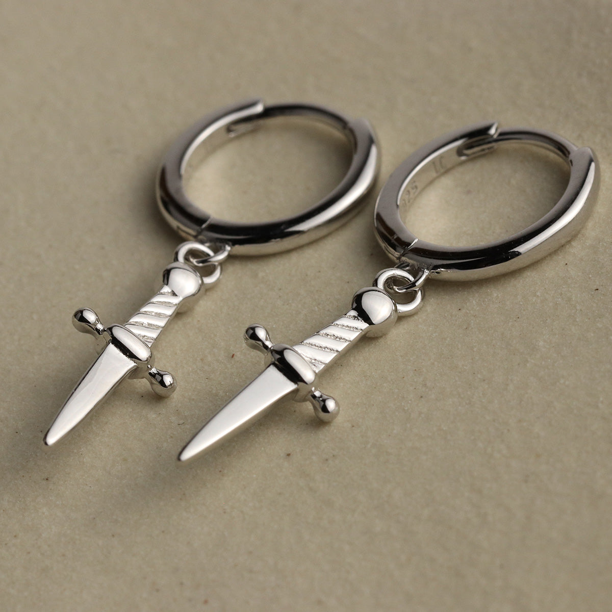 Mini daggers hoop earrings in sterling silver with a snap close.