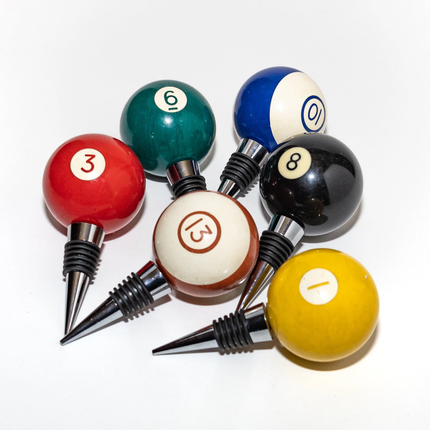 Set of billiard ball wine bottle stoppers on a white background